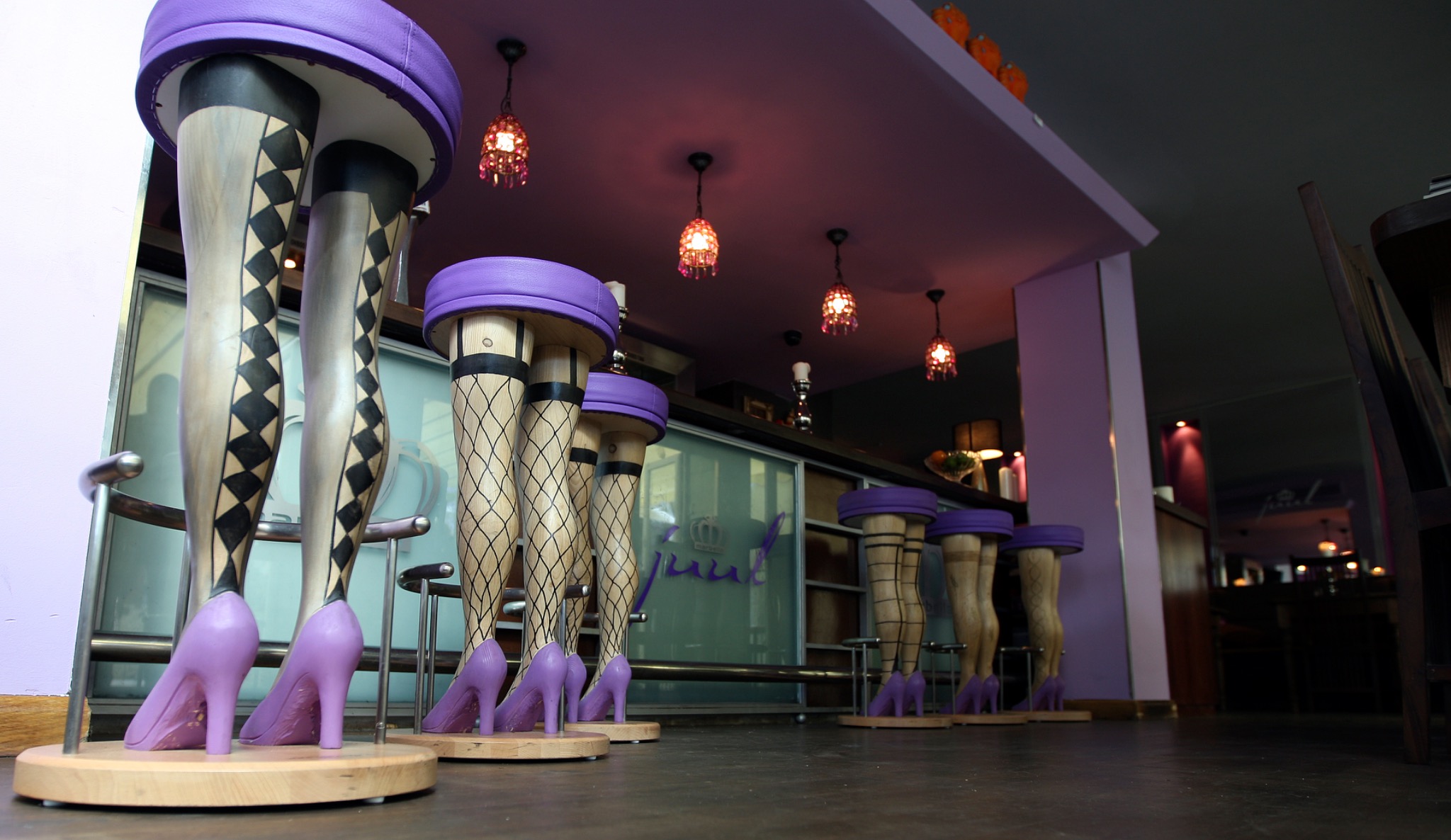 Purple leg-shaped bar stools at Grand Café Juul in Marbella